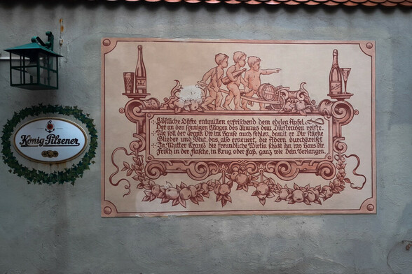 Wandbild auf einer hessischen Hauswand, in alter Schrift den Apfelwein preisend