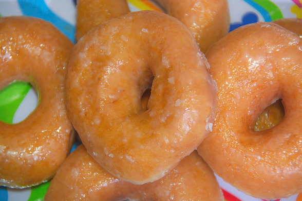 Photo of a plateful of fresh glazed donuts ready to be devoured 