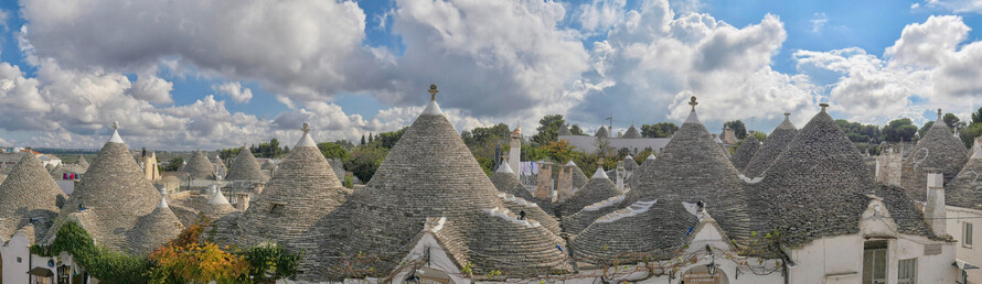 Alberobello is a small town in Puglia in southern Italy with a quarter of houses known as 'Trulli' which describes the roofs which are set in a decorative pinnacle. The story is that when the Italian tax collectors came, the houses were built on drystone so easily dismantled to avoid tax. 