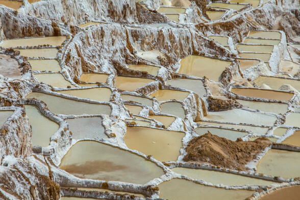 High angle view on the Salinas de Maras, Pre Inca traditional salt mine (salinas) in Peru.

Maras is a town in the Sacred Valley of the Incas, 40 kilometers north of Cuzco, in the Cuzco Region of Peru. The town is well known for its salt evaporation ponds, located towards Urubamba from the town center, which have been in use since Inca times. 