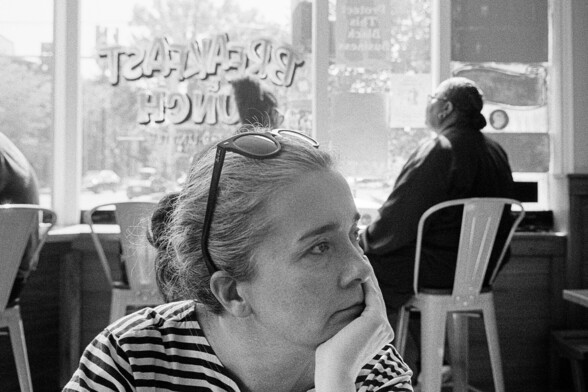 A woman awaits her food at a restaurant.
