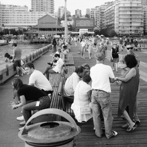 People congregate on the pier. A man looks over.