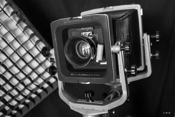 Großformatkamera in einem Fotostudio, links ein Lichtformer mit Gitterwabe.