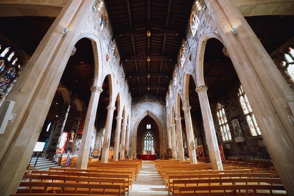 The nave of a cathedral, with huge pillars and archway lining the nave on each side.