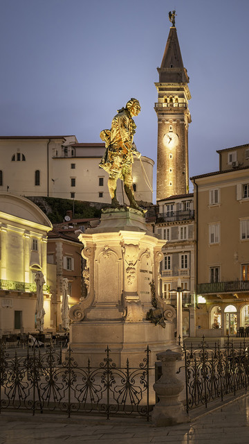 Nighttiime photo of Tartini Square in Piran Slovenia, featuring the monument of Giuseppe Tartini a composer and violinist. 