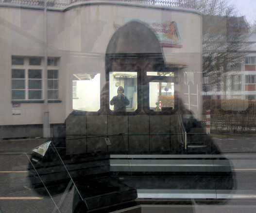 Doppelselfie in einer Vitrine, hinter der mehrere Spiegel an der Wand hängen.