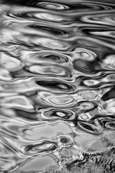 Abstract patterns of ripples on water surface in grayscale.