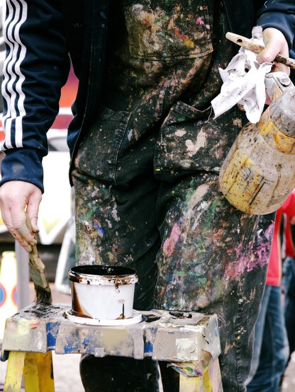 The paint-spattered overalls of one of the street artists