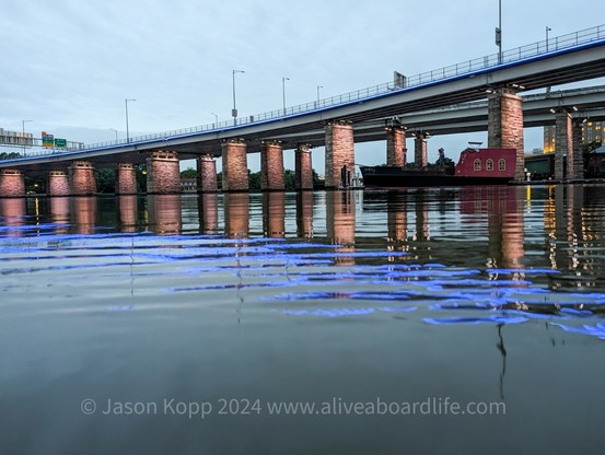 395 bridge over the Washington Channel with cloudy skies and blue led reflecting in water