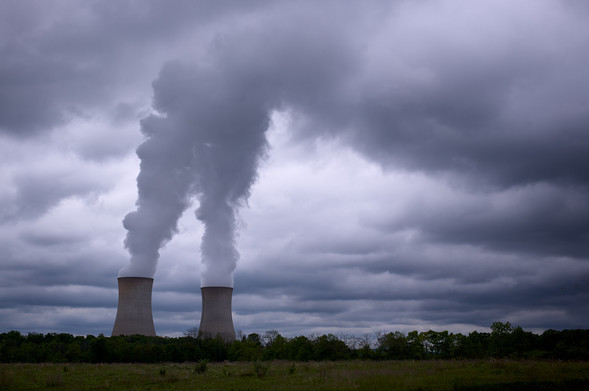 Nuclear cooling tower with steam rising toward the cloudy sky. The steam blends together with the clouds giving the appearance that the cooling towers are producing all the clouds in the sky.