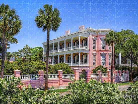 Jigsaw Puzzle: Charleston SC mansion, the Palmer Home, on a bright sunny day showing stately palm trees around the pink mansion with stunning white columns. From the Fine Art Gallery of Shelia Hunt.
