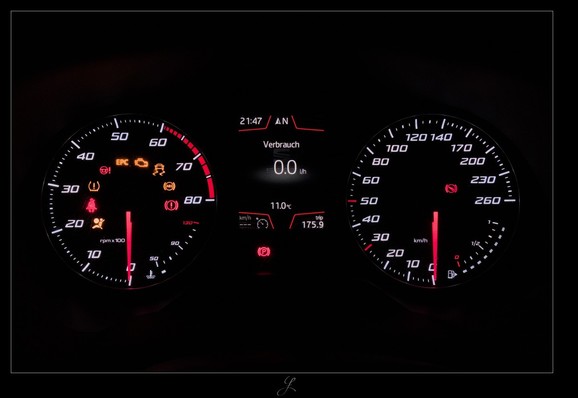 
The modern cockpit of a car, taken as a long exposure at night. Everything around the cockpit is black. Only a small glimmer of the illuminated instruments can be seen, fading into the black background. One round instrument for the engine speed on the left, one for the road speed on the right. The instrument pointers are red, the digits are light gray, and certain limit markings are also red. In the middle between the two instruments, the on-board computer display shows various figures and information in light gray. Red frame lines separate areas of the display. Below the on-board computer display and in the round instruments are a series of symbols that indicate various information and the status of the vehicle.

AI disclaimer: Using my work, its meta data, written or derived description to create media with or train AI based systems is prohibited.