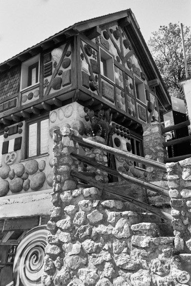 A black-and-white film photo of the Hansel and Gretel House in Soportújar. In reality, the house is multi-coloured with loads of sweets and snacks plastered over the walls.