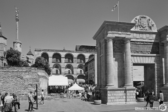 A black-and-white film photo of Puerta del Puente and the rear wall of the Mezquita-Catedral de Córdoba behind.