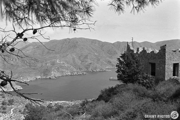 A black-and-white film photo of the view of the coast from Batería de Castillitos. It looks just like a Norwegian fjord.