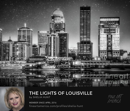 Black-and-white image of Louisville, Kentucky skyline at night, showing the lights of the city skyscrapers reflecting in the Ohio River. The twinkling stars added to the ambience, along with the reflection of the skyscrapers in the beautiful Ohio River.  If you look closely, you will see the  Belle of Louisville riverboat docked on the lovely waterfront. Image from the Fine Art Gallery of Shelia Hunt.