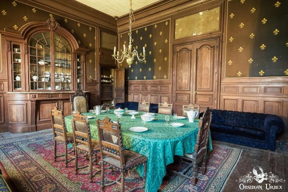 dining room with wooden panel walls and blue table cloth