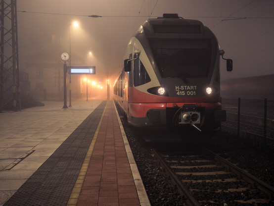 S-Bahn abends am Bahnhof, von schräg vorne fotografiert. Neblige Stimmung. 