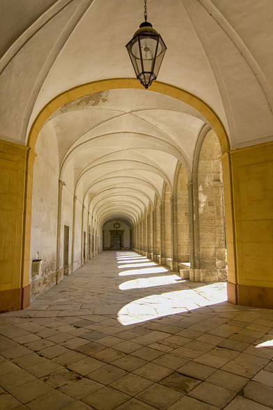 Sunlight through the arches of a corridor in a medieval cloister in Cluny, France