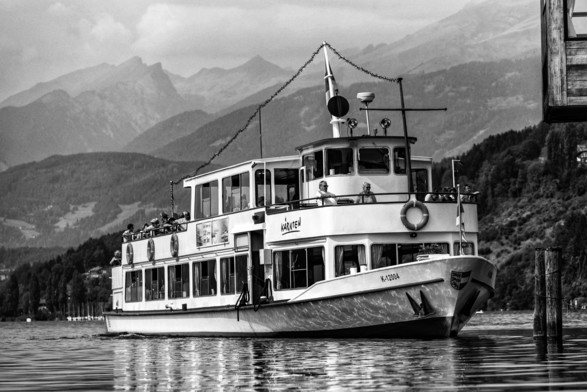 Personenschiff bei der Anfahrt zur Anlegestelle Millstatt/Millstätter See. 
Im Hintergrund ein Bergpanorama. 

Passenger ship approaching the Millstatt/Millstätter See landing stage. 
A mountain panorama in the background. 

