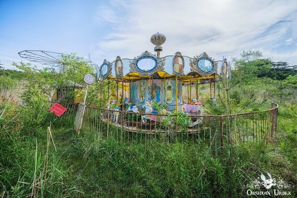 old fun fair carousel covered with plants and obscured the grass
