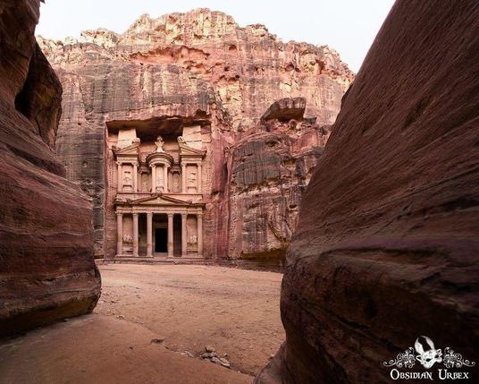 petra, the Treasury carved out of red sandstone at the end of a red sandstone canyon