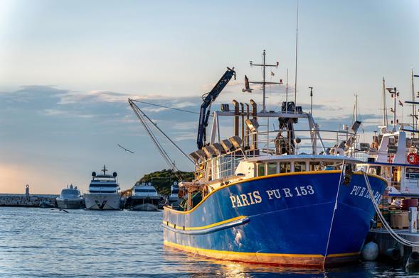 Ein Trawler mit dem Namen Paris bei goldenen Abendlicht an seiner Anlegestelle im Hafen. 

A trawler named Paris in the golden evening light at its mooring in the harbour.