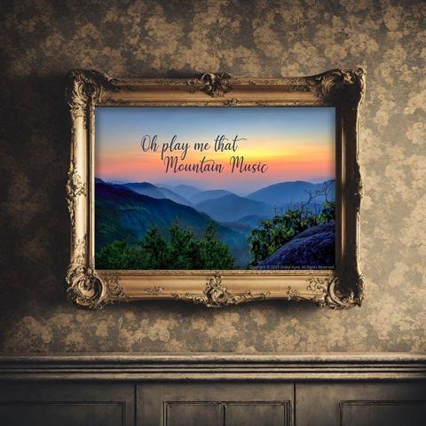 “Oh Play Me That Mountain Music” is a stunning view of sunset in the Blue Ridge Mountains, with the words written on the image.  The sunset is aglow with hues of yellow, pink and orange, set against the hazy blue ridges. From the Fine Art Gallery of Shelia Hunt.