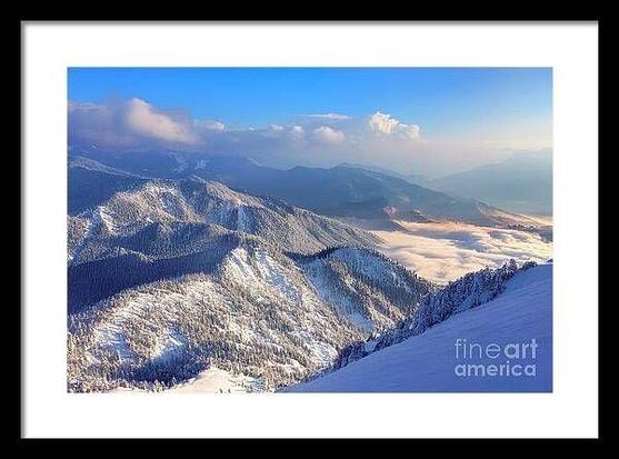 Winter snow scene in the Blue Ridge Mountains of North Carolina, featuring snow-covered peaks, valleys, and fog. The deep blue sky contrasts with soft puff clouds, with sunlight gently illuminating the mountain tops. Taken near Mount Mitchell, just off the Blue Ridge Parkway, this serene landscape captures the essence of a winter day in the mountains.   From the Fine Art Gallery of Shelia Hunt at Shelia-Hunt.pixels.com