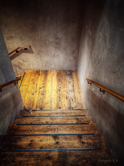 Wooden stairs and handles on grey concrete wall