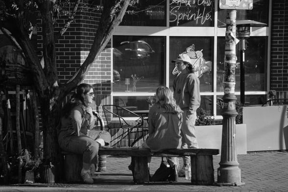 Three people talking on a street corner