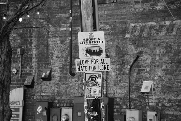An adopt a street sight that says love for all hate for none”