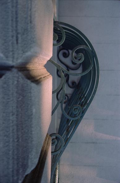  profile view of a rounded wrought iron window grate set in stone walls. In Budapest, Hungary.