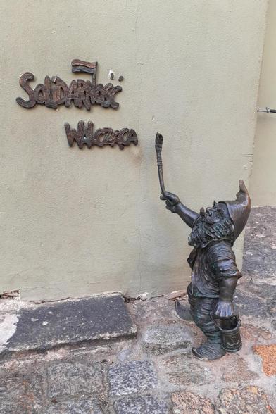 Ein Zwerg pinselt einen Solidarnosc-Schriftzug an die Wand