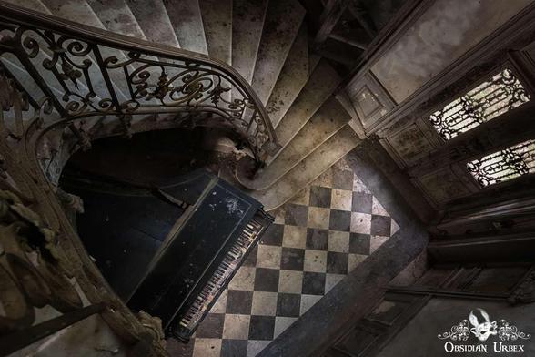 photo of piano at the foot of spiral stairs