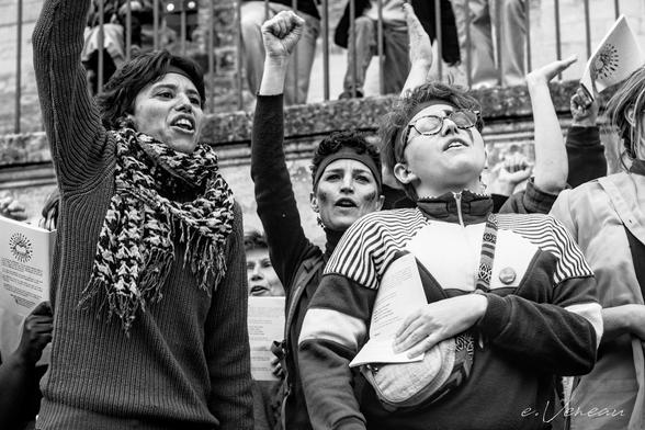 During the performance of the feminist choir, the singers take up protest songs: two women have their fists raised, the third has her eyes closed and her head towards the sky.