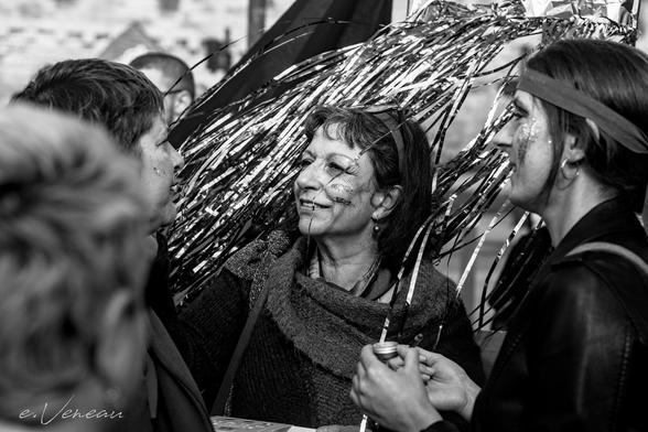 A woman applies glitter to another woman's face before the start of the demonstration.