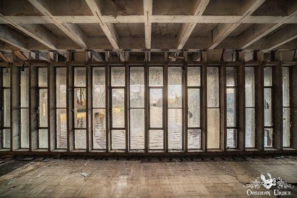 glasswork, brutalist with rectangle panels. looking out over water 
