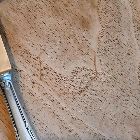 Der Abdruck des Kaffeeglas auf dem Küchentisch.
Mit Messer im Anschnitt am Rand, quadratisch.
