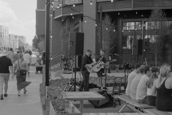A two-piece band playing at the outdoor seating area of a local brewery