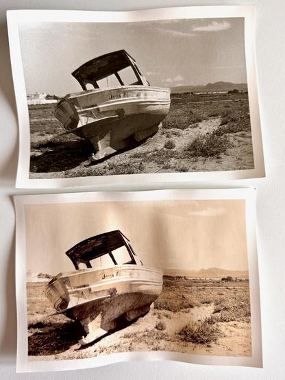A black and white darkroom print of two boats on a sandy beach. There are two versions of the same print; a normal print and a lith print. The with print has yellow/brown tones.
