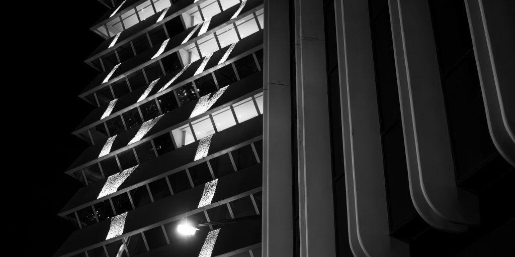 A monochrome view of two modern buildings giving an image with two different textures and patterns and creating an abstract composition.