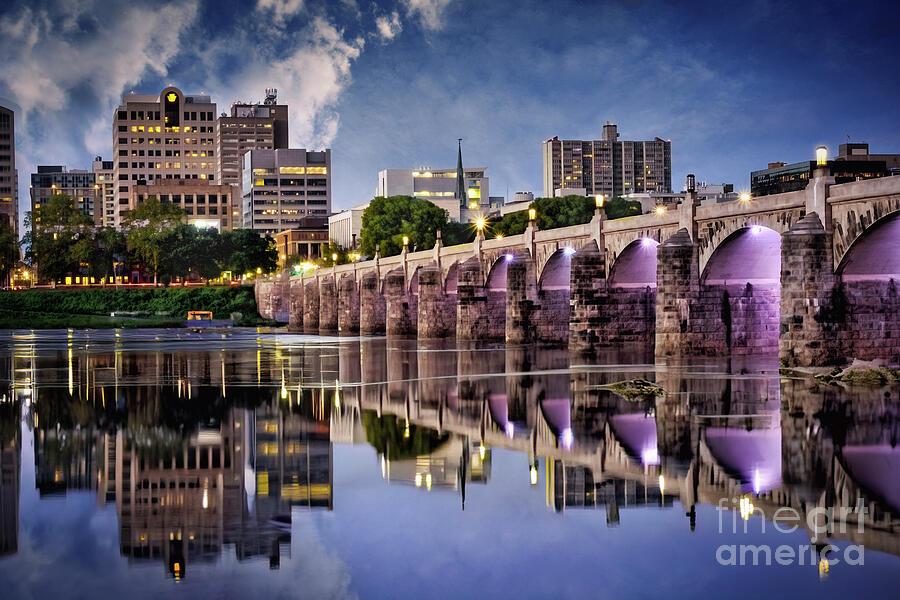 Harrisburg, the capital city of Pennsylvania. is a lovely town. The picturesque Market Street Bridge is shown here spanning the waters of the Susquehanna River. This postcard-type photograph was taken in late afternoon, and the reflection of the blue sky and bridge in the water was stunning. This artwork is from the Fine Art Gallery of Shelia Hunt.