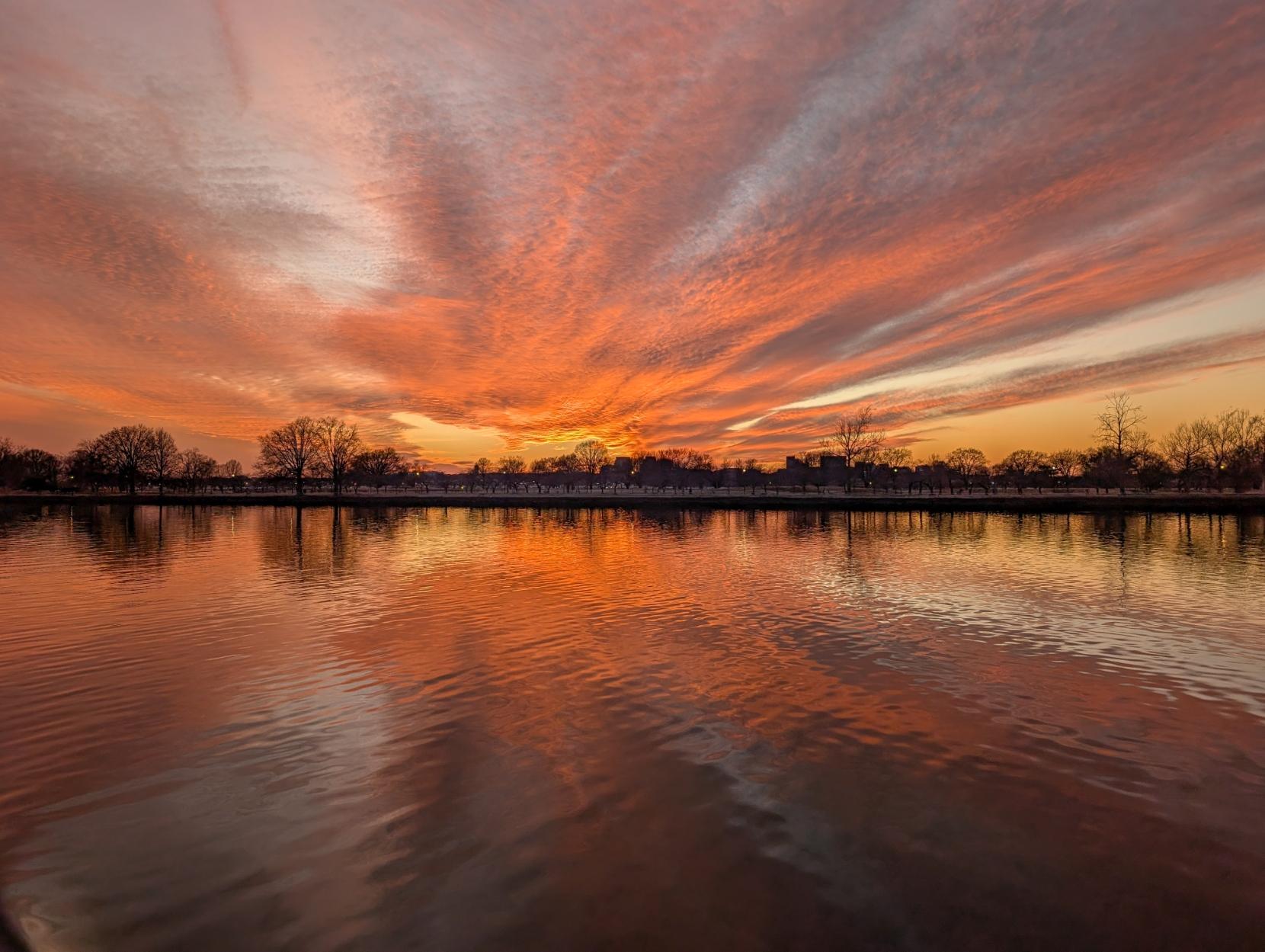 Pink and purple clouds over calm water reflecting in the Washington Channel