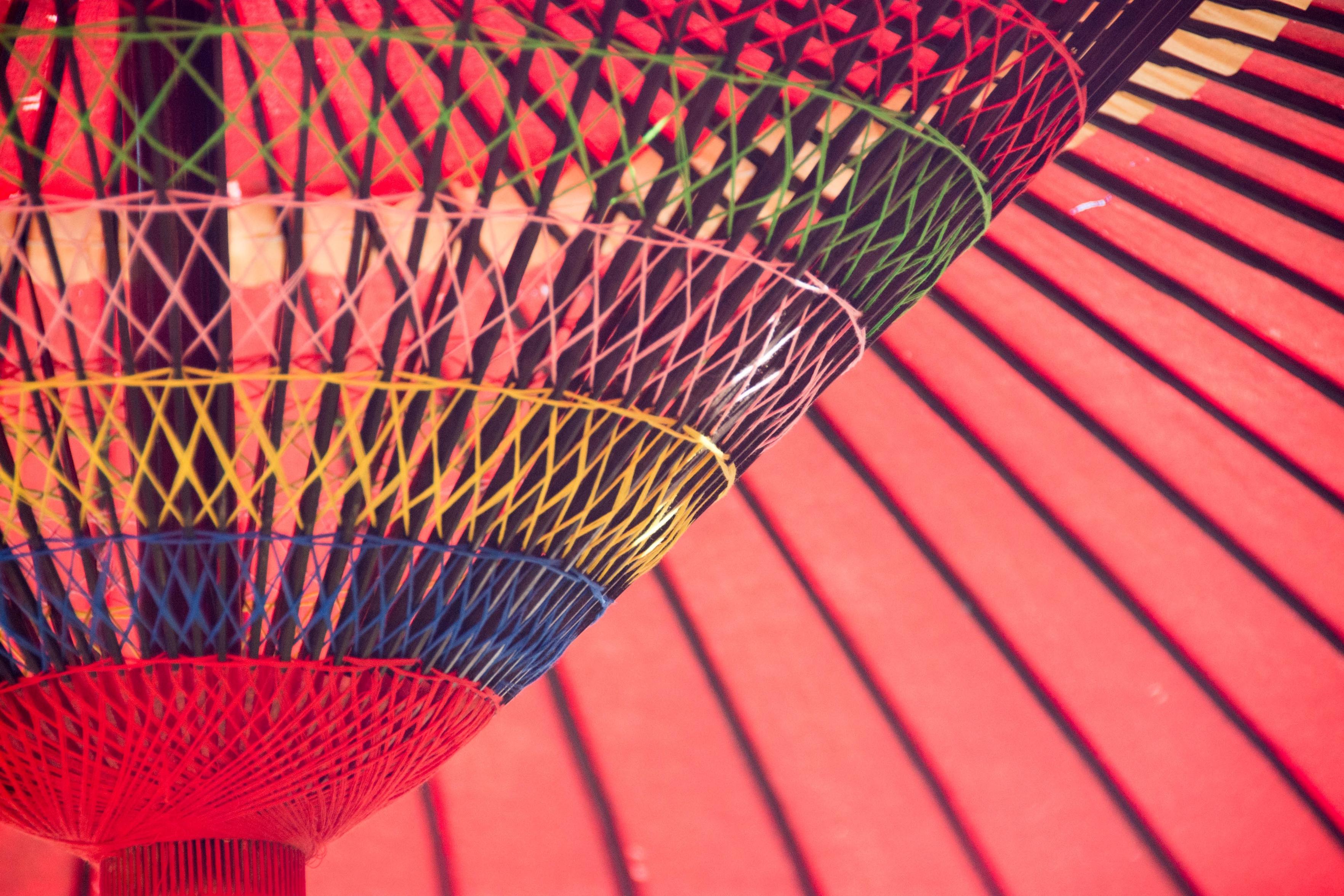 Close-up of a colorful traditional umbrella featuring a vibrant inner structure with a red exterior and patterns in yellow, green, and blue.