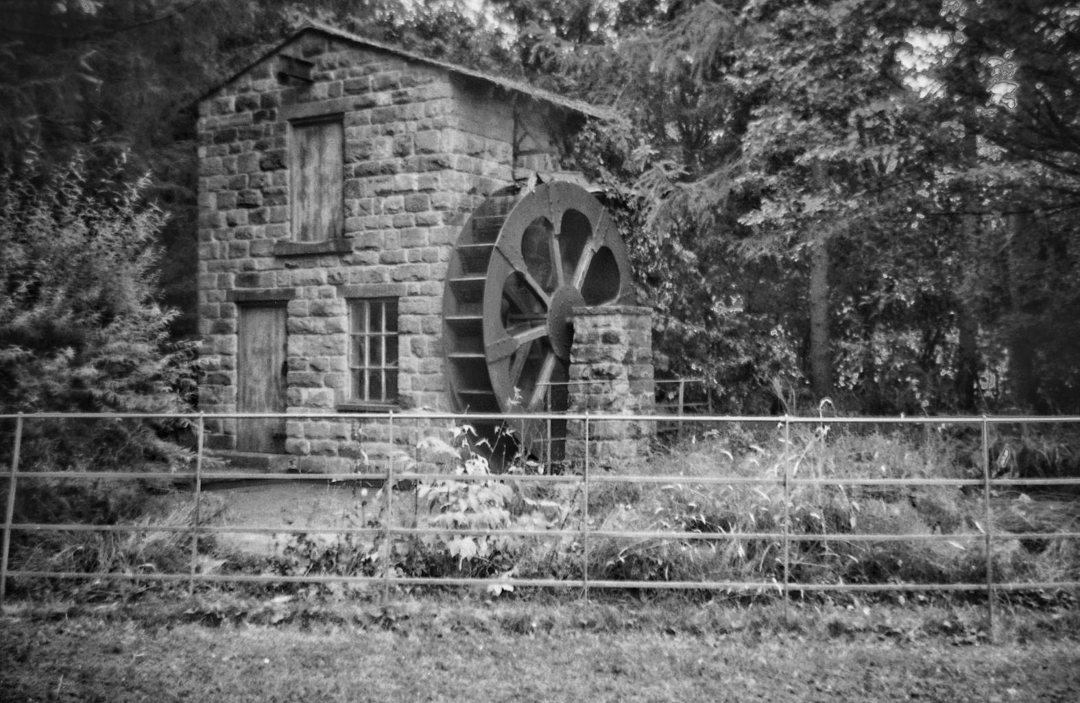 A grainy monochrome photo of a reconstructed watermill in Roundhay Park, Leeds.