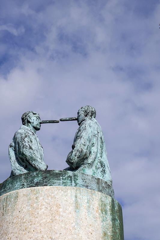 Pinocchio Effect - The sculpture *The Liars* by Dutch artist Nicolas Dings in Osnabruck, Lower Saxony, Germany. Created in 2005, the work consists of two kneeling bronze figures with long Pinocchio noses on a terrazzo stele and, through its exaggerated Renaissance grotesque style, explores the question of truth and deception.