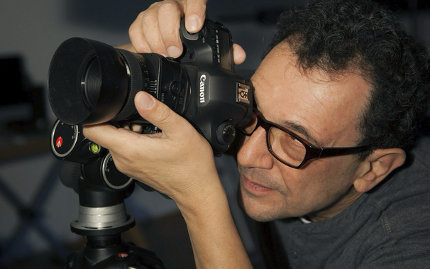 Eberhard Schuy mit einer Canon Kamera und einem montierten Til Shift Objektiv im Anschlag bei ihm fotografieren