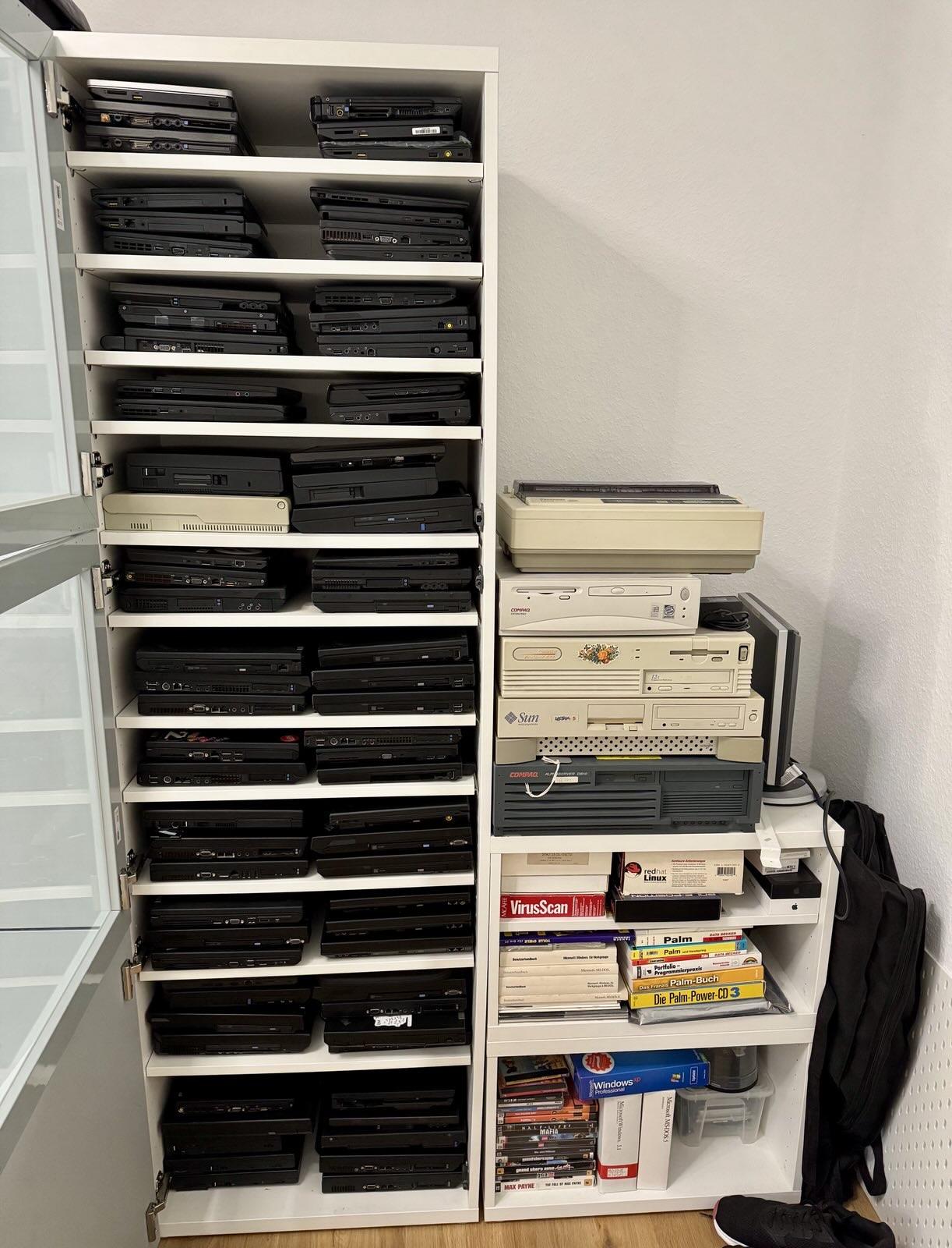 A cupboard full of roughly 85 ThinkPads, next to another cupboard full of retro machines and software boxes.