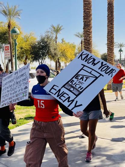Sign reads no you are enemy. It’s a guillotine with eat the rich written on it.